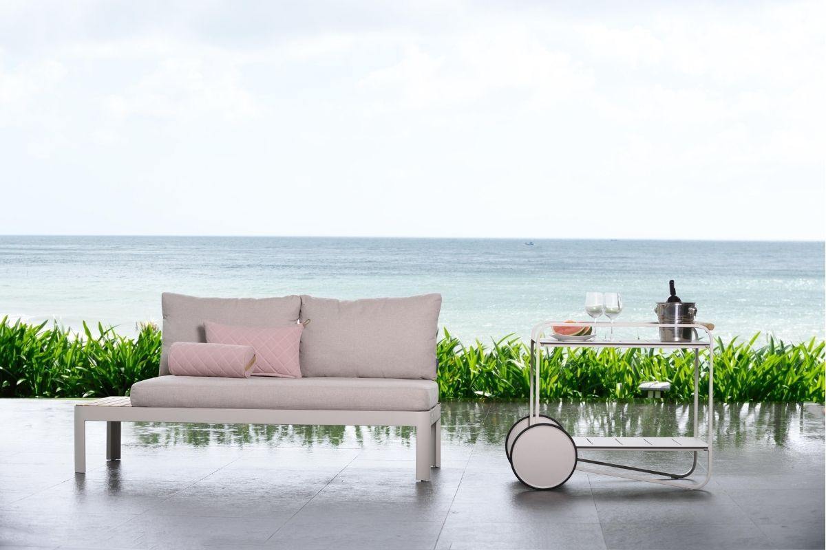 Pink tea trolley next to pink sofa, patio, sea view