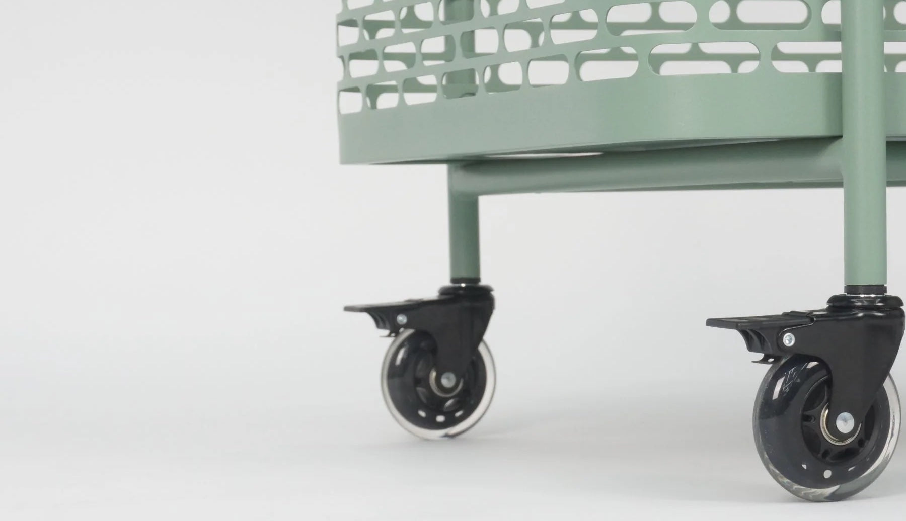 The bottom tray and wheels of a green bar cart